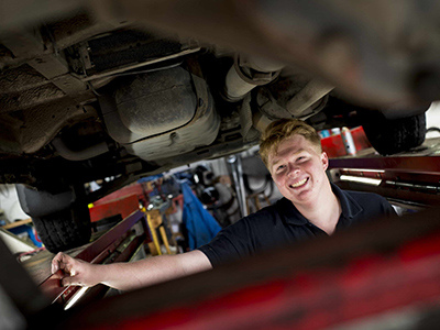 Photo of a man working under a car